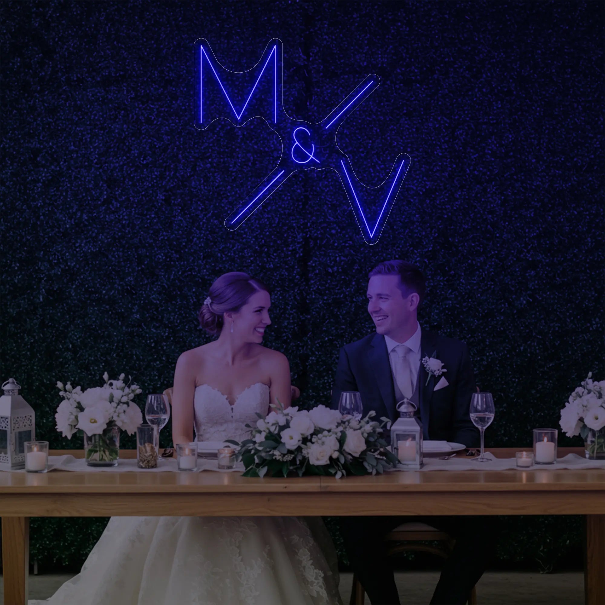 Photo of the 'Wedding Initials Custom Neon Sign V1' neon sign glowing in deep blue against a styled interior wall.