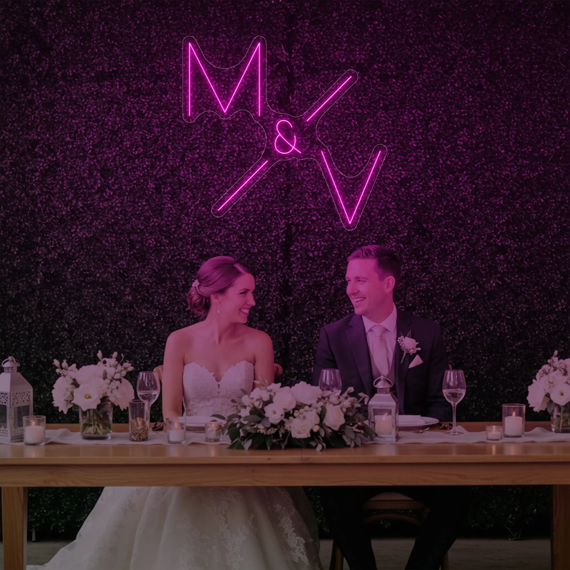 Photo of the 'Wedding Initials Custom Neon Sign V1' neon sign glowing in light pink against a styled interior wall.
