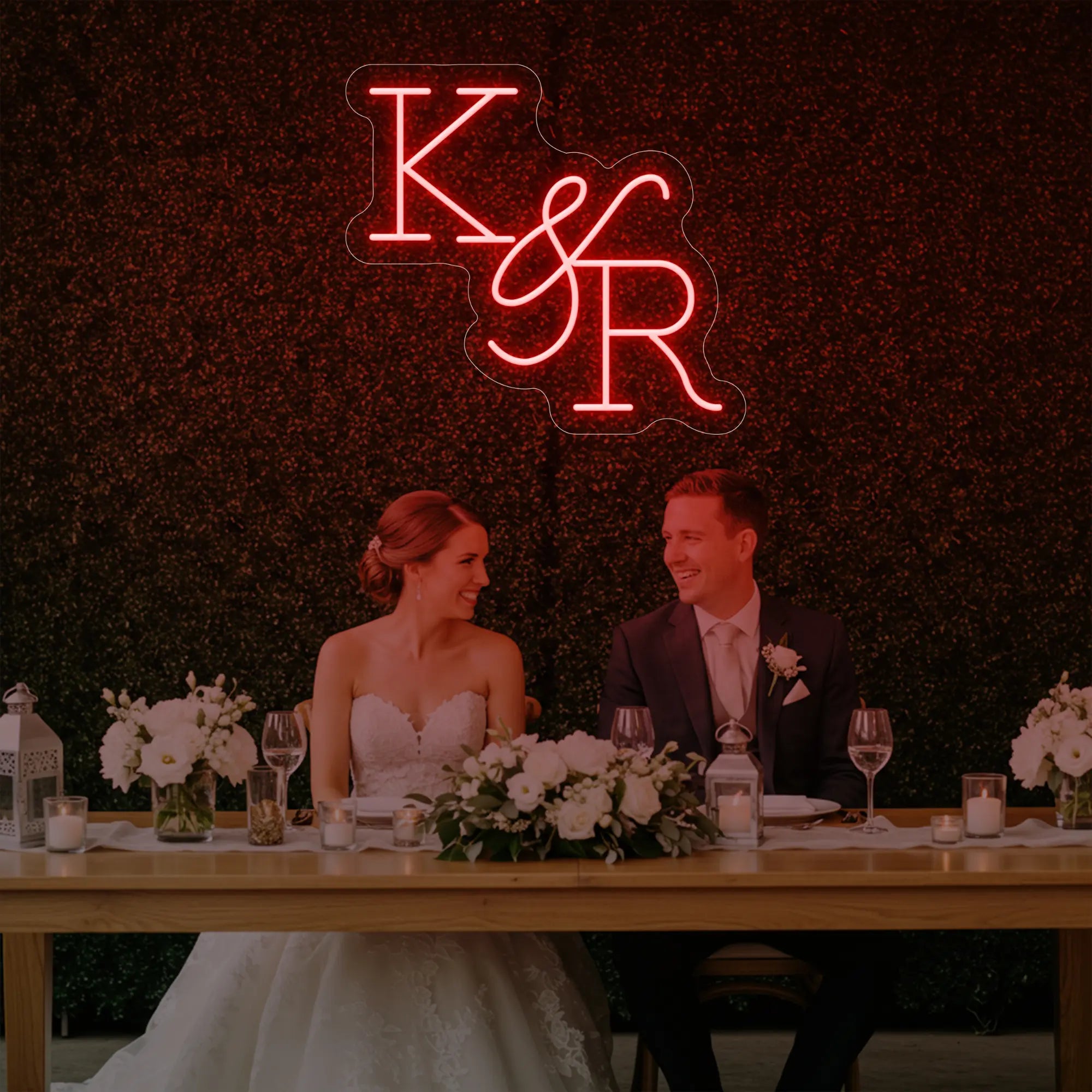 Photo of the 'Wedding Initials Custom Neon Sign V2' neon sign glowing in red against a styled interior wall.