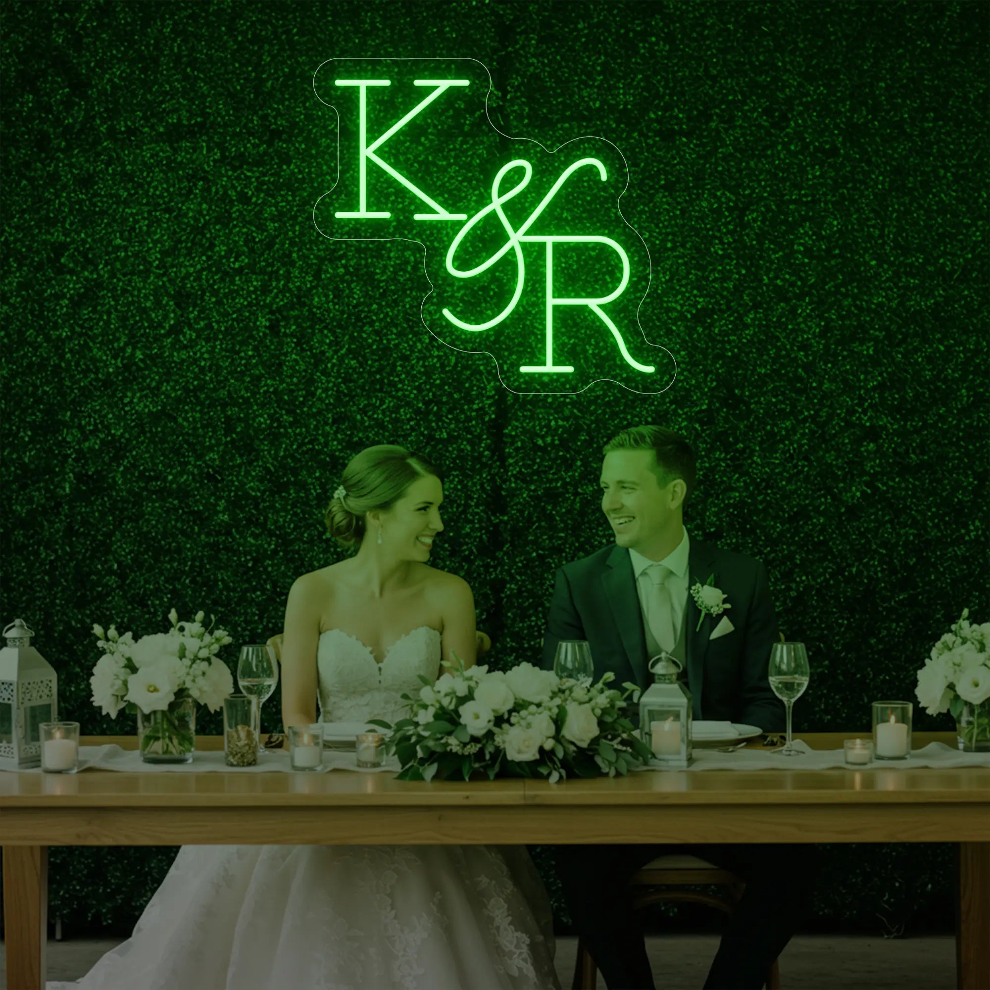 Photo of the 'Wedding Initials Custom Neon Sign V2' neon sign glowing in green against a styled interior wall.