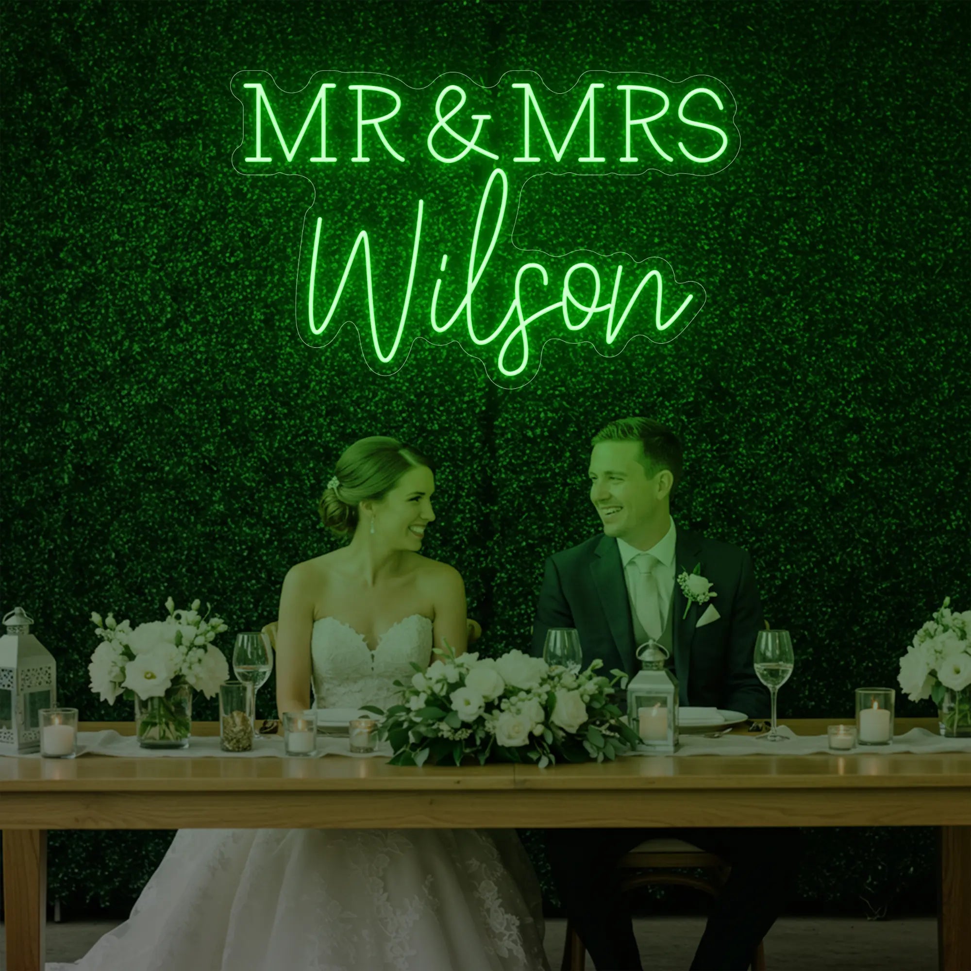 Photo of the 'Wedding Last Names Custom Neon Sign V2' neon sign glowing in green against a styled interior wall.