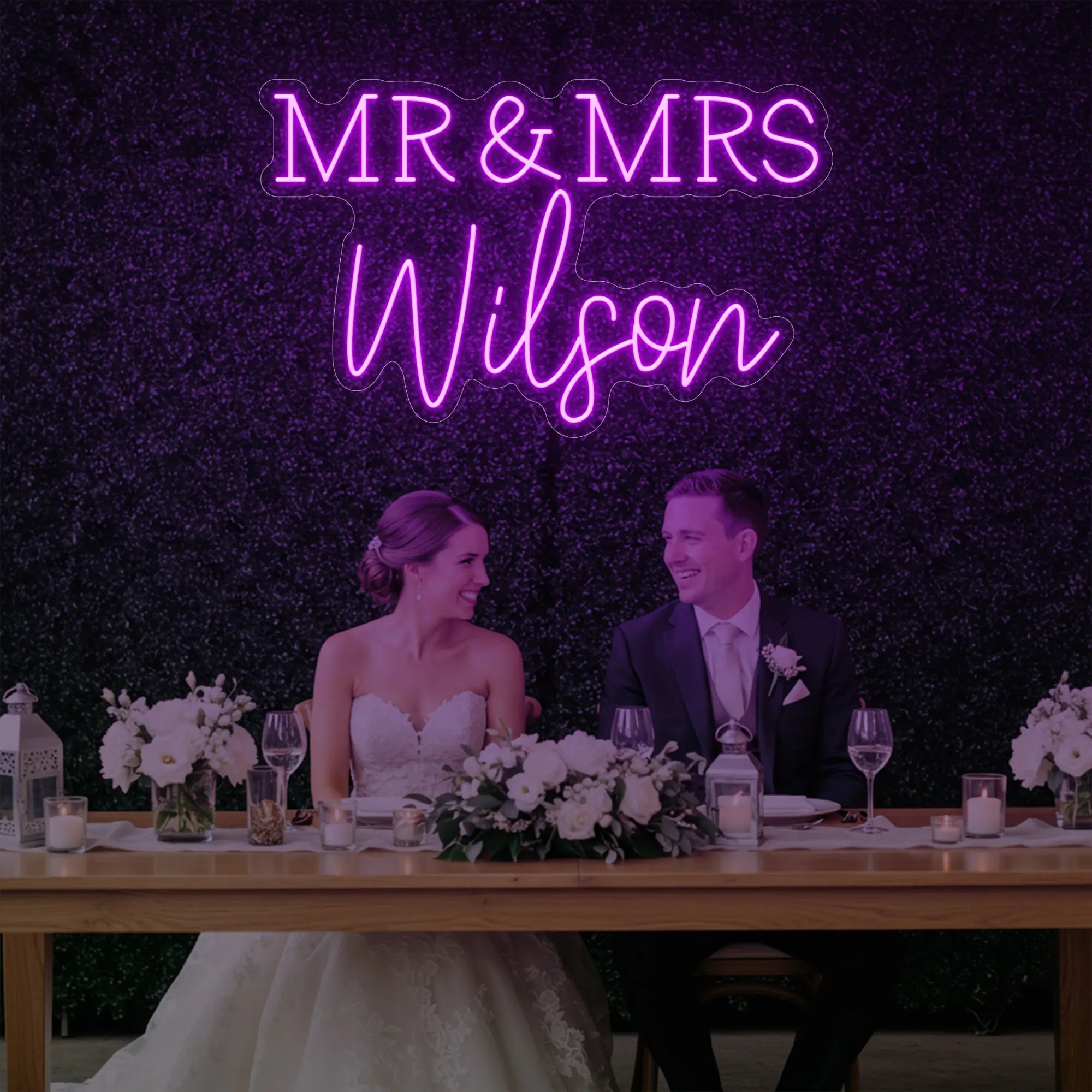 Photo of the 'Wedding Last Names Custom Neon Sign V2' neon sign glowing in deep pink against a styled interior wall.