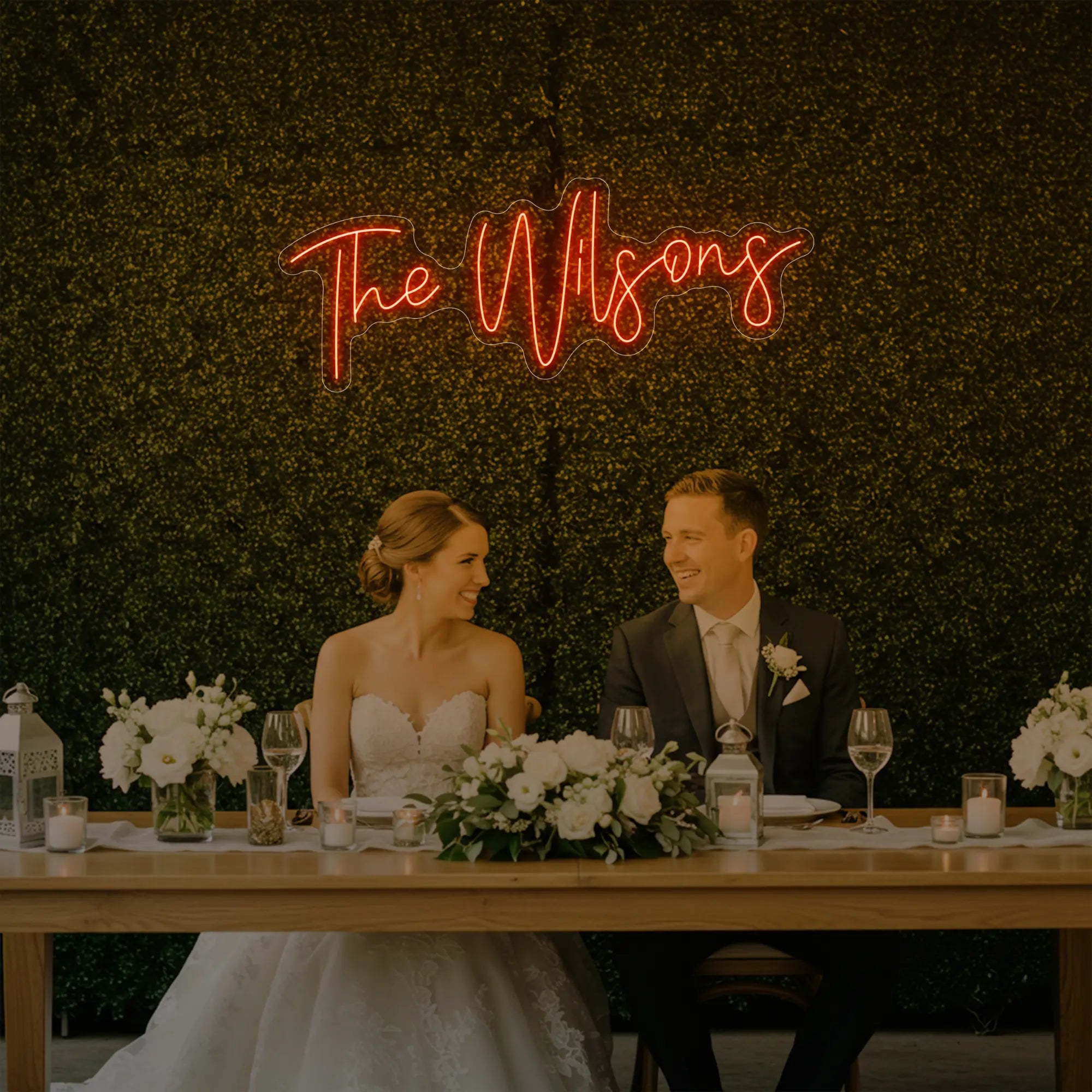 Photo of the 'Wedding Last Names Custom Neon Sign V4' neon sign glowing in golden yellow against a styled interior wall.