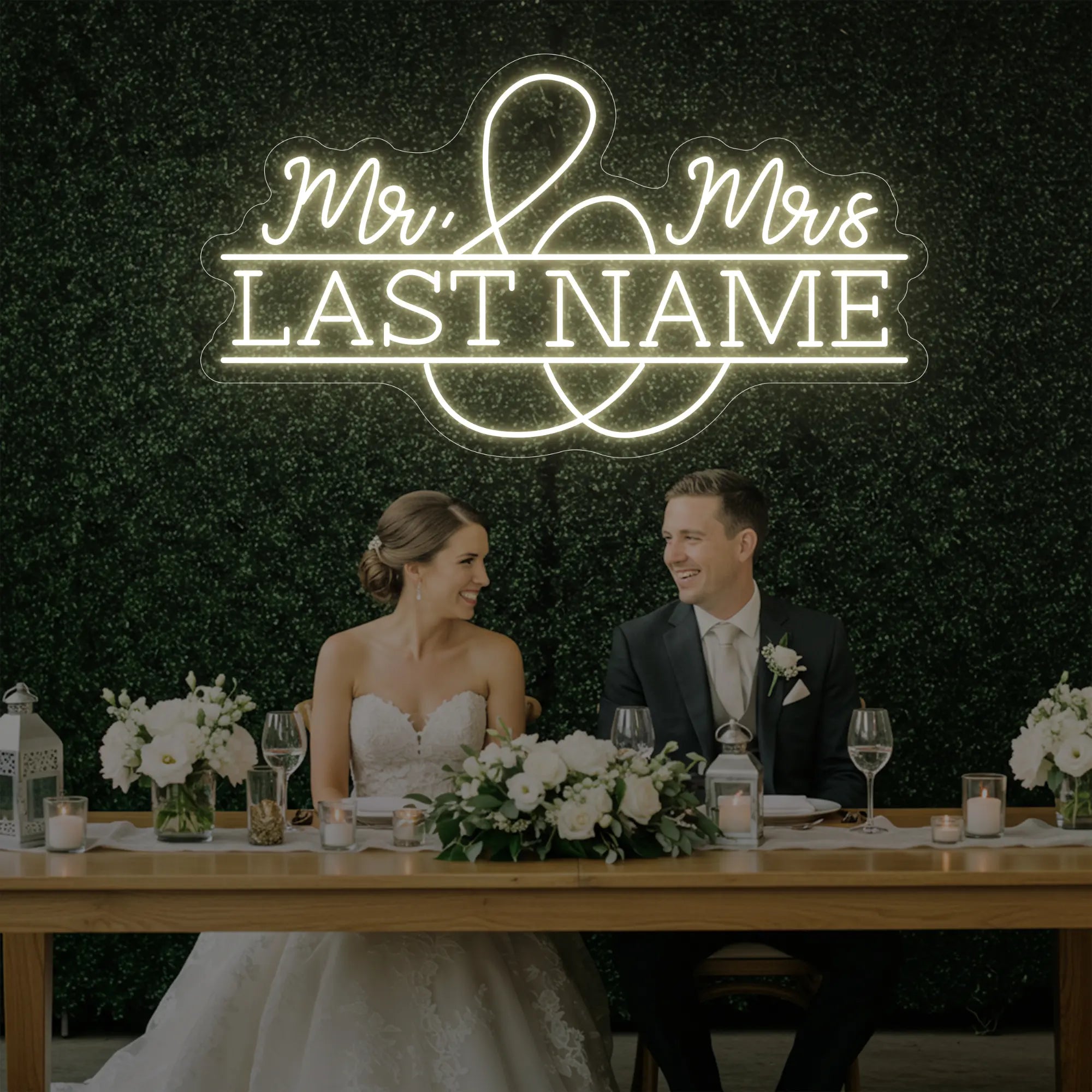 Photo of the 'Wedding Last Names Custom Neon Sign V6' neon sign glowing in warm white against a styled interior wall.