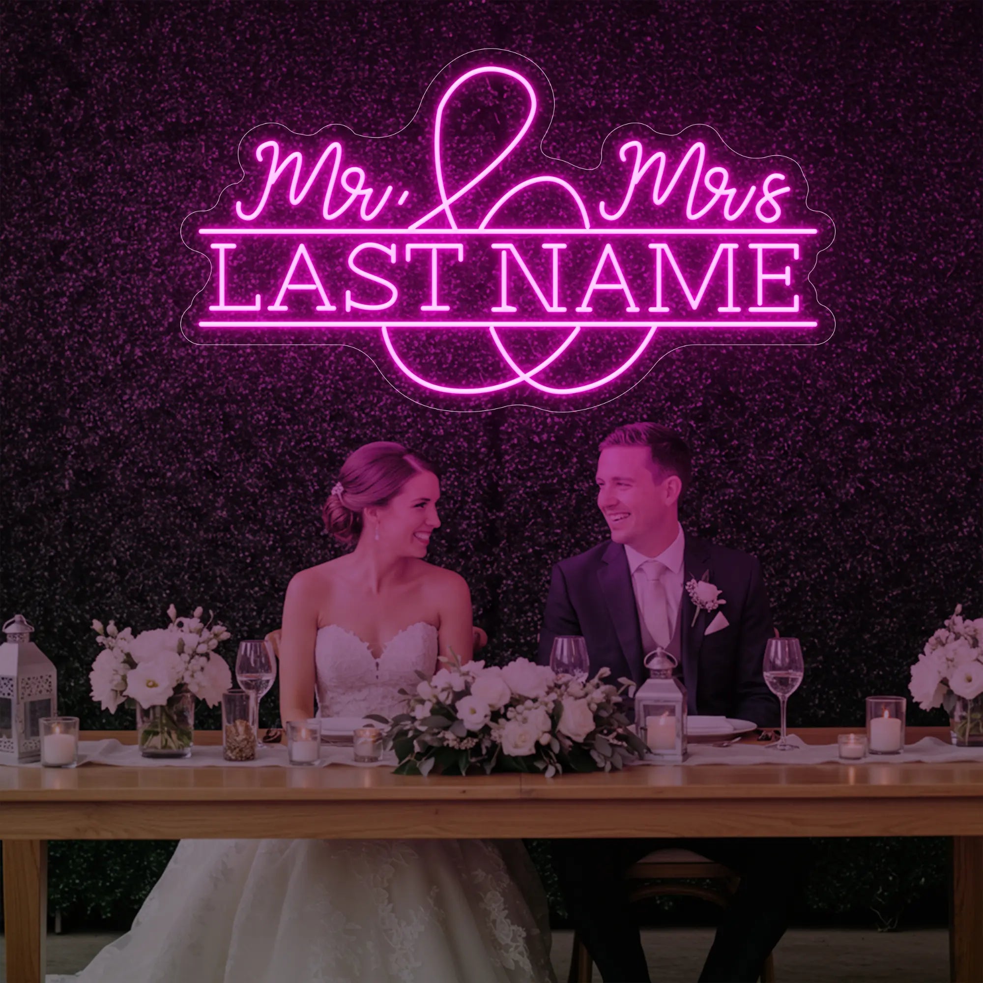 Photo of the 'Wedding Last Names Custom Neon Sign V6' neon sign glowing in light pink against a styled interior wall.