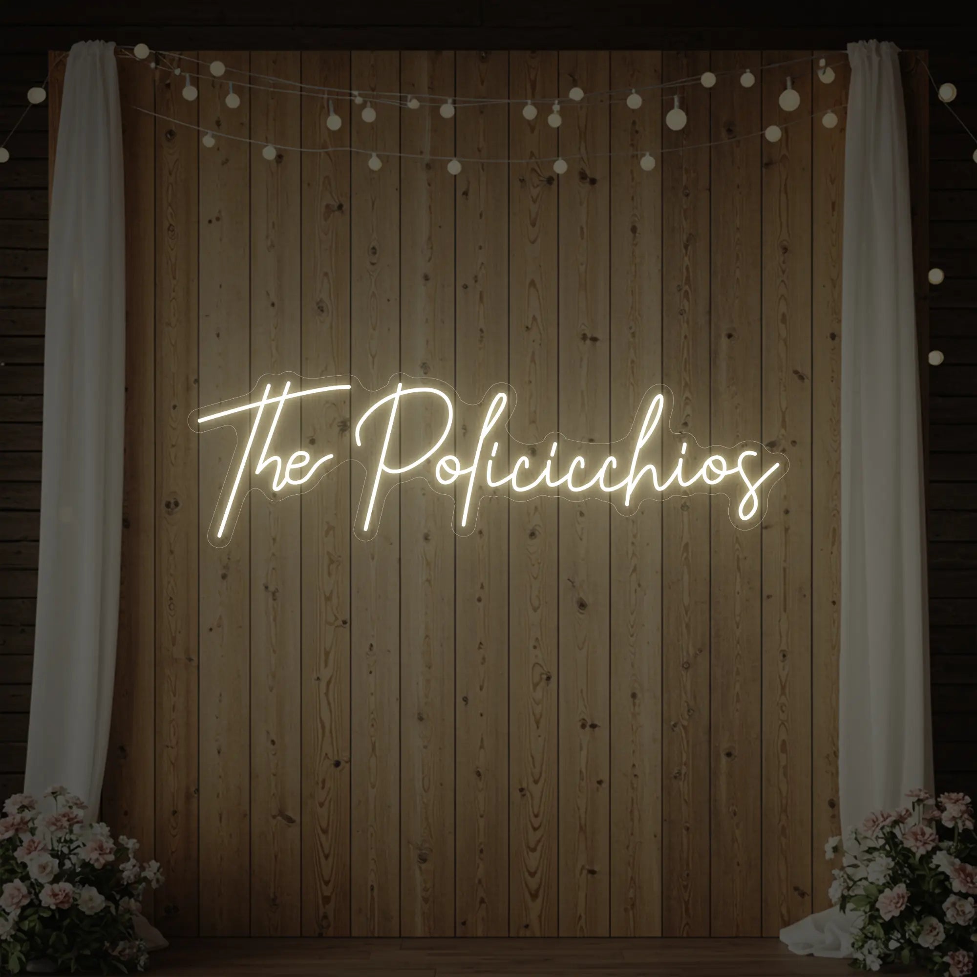 Photo of the 'Wedding Last Names Custom Neon Sign V7' neon sign glowing in warm white against a styled interior wall.