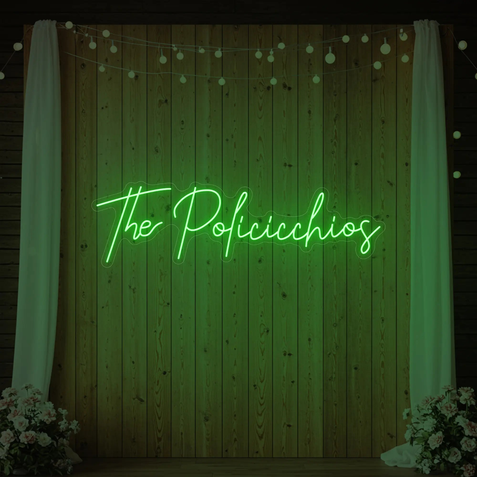 Photo of the 'Wedding Last Names Custom Neon Sign V7' neon sign glowing in green against a styled interior wall.