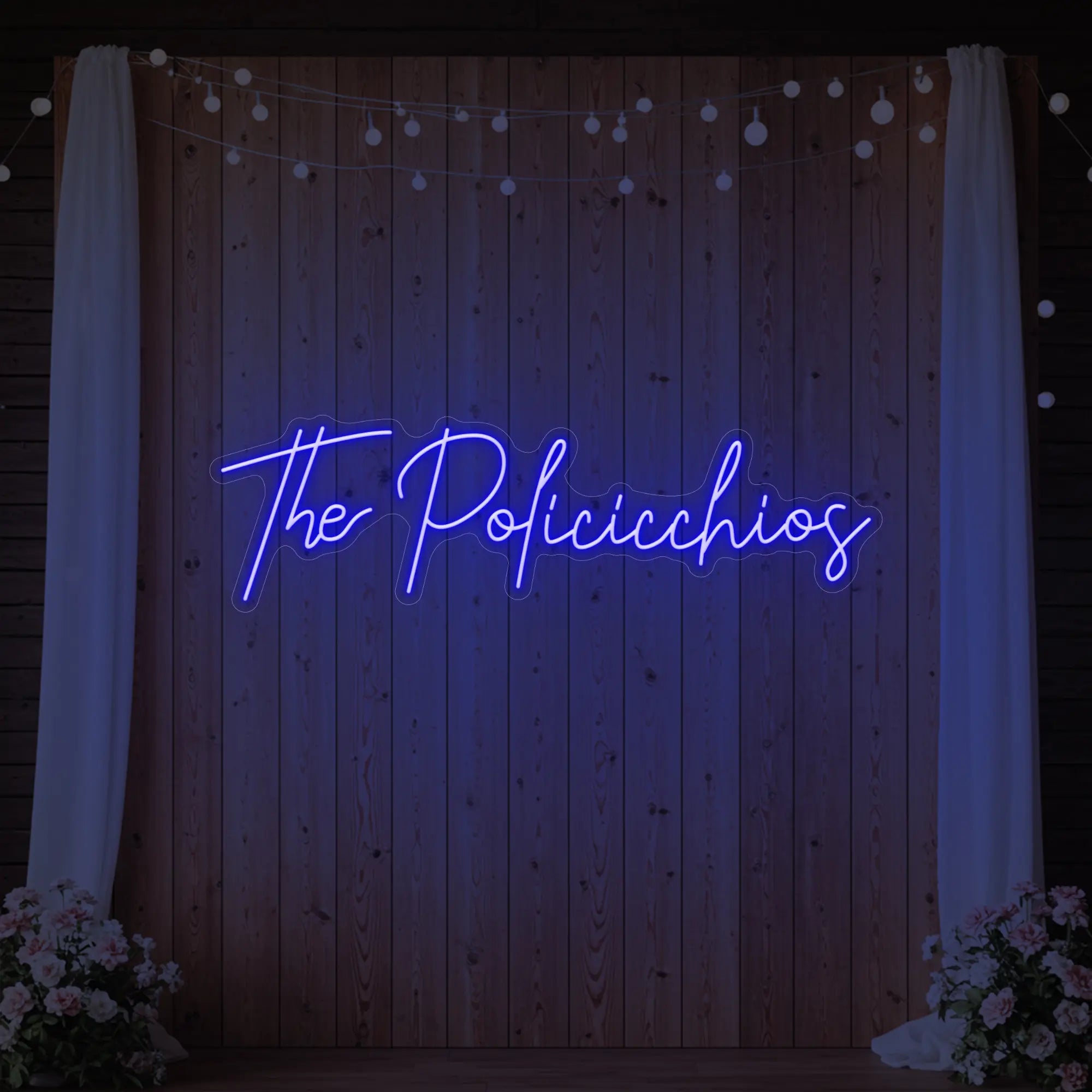Photo of the 'Wedding Last Names Custom Neon Sign V7' neon sign glowing in deep blue against a styled interior wall.