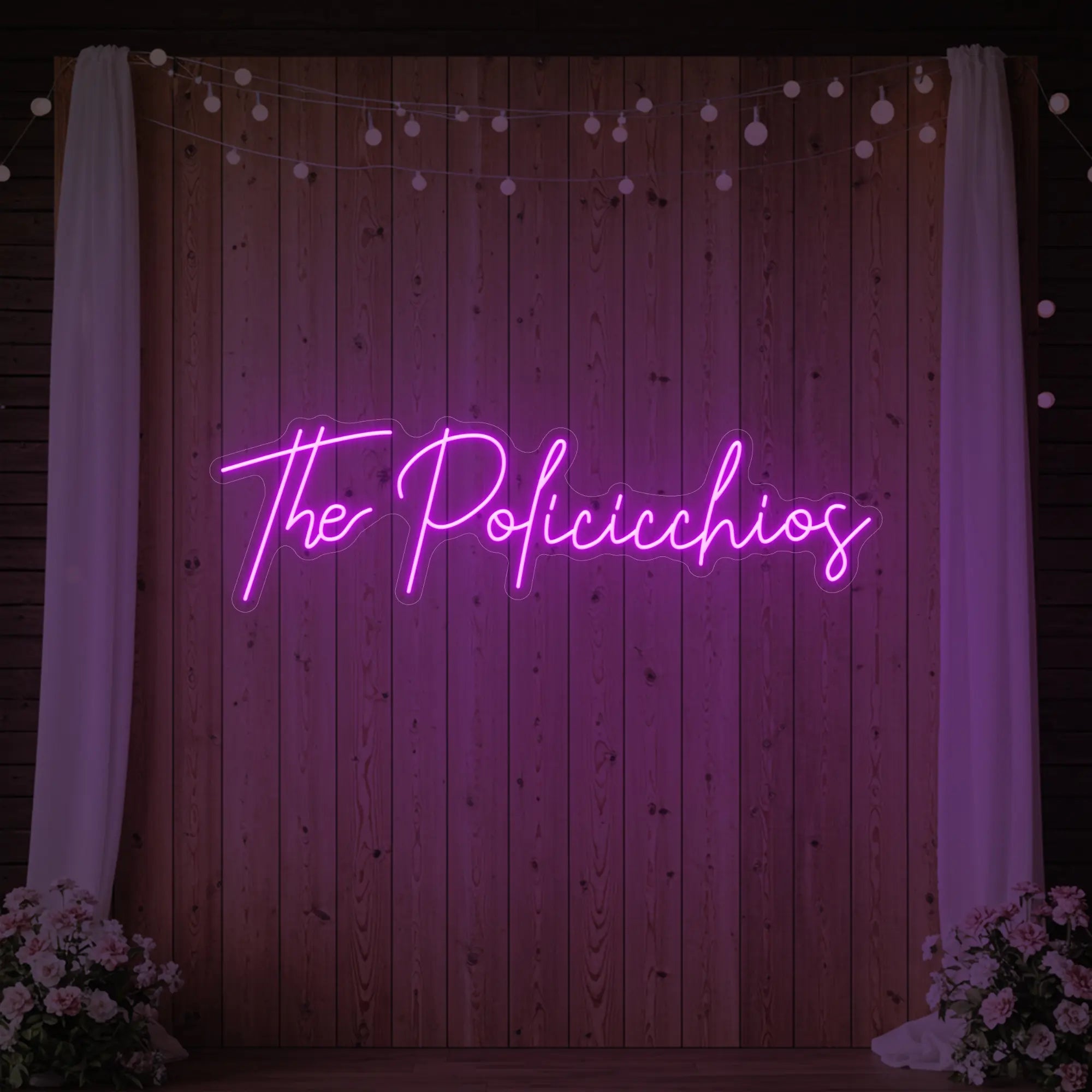 Photo of the 'Wedding Last Names Custom Neon Sign V7' neon sign glowing in deep pink against a styled interior wall.