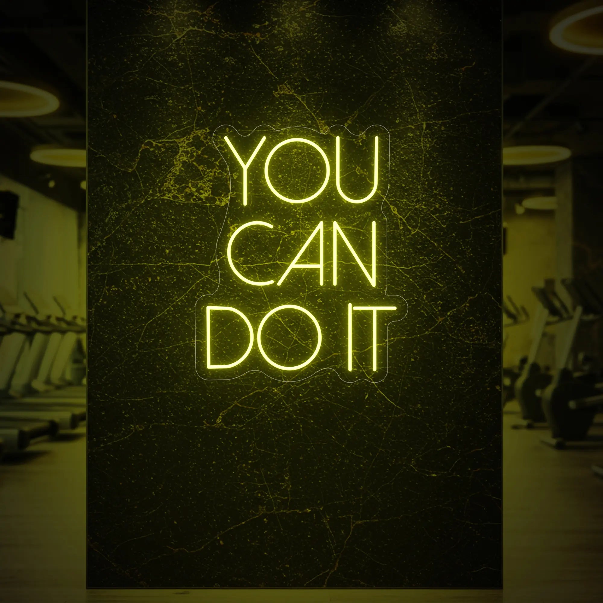 Photo of the 'YOU CAN DO IT' neon sign glowing in lemon yellow against a styled interior wall.