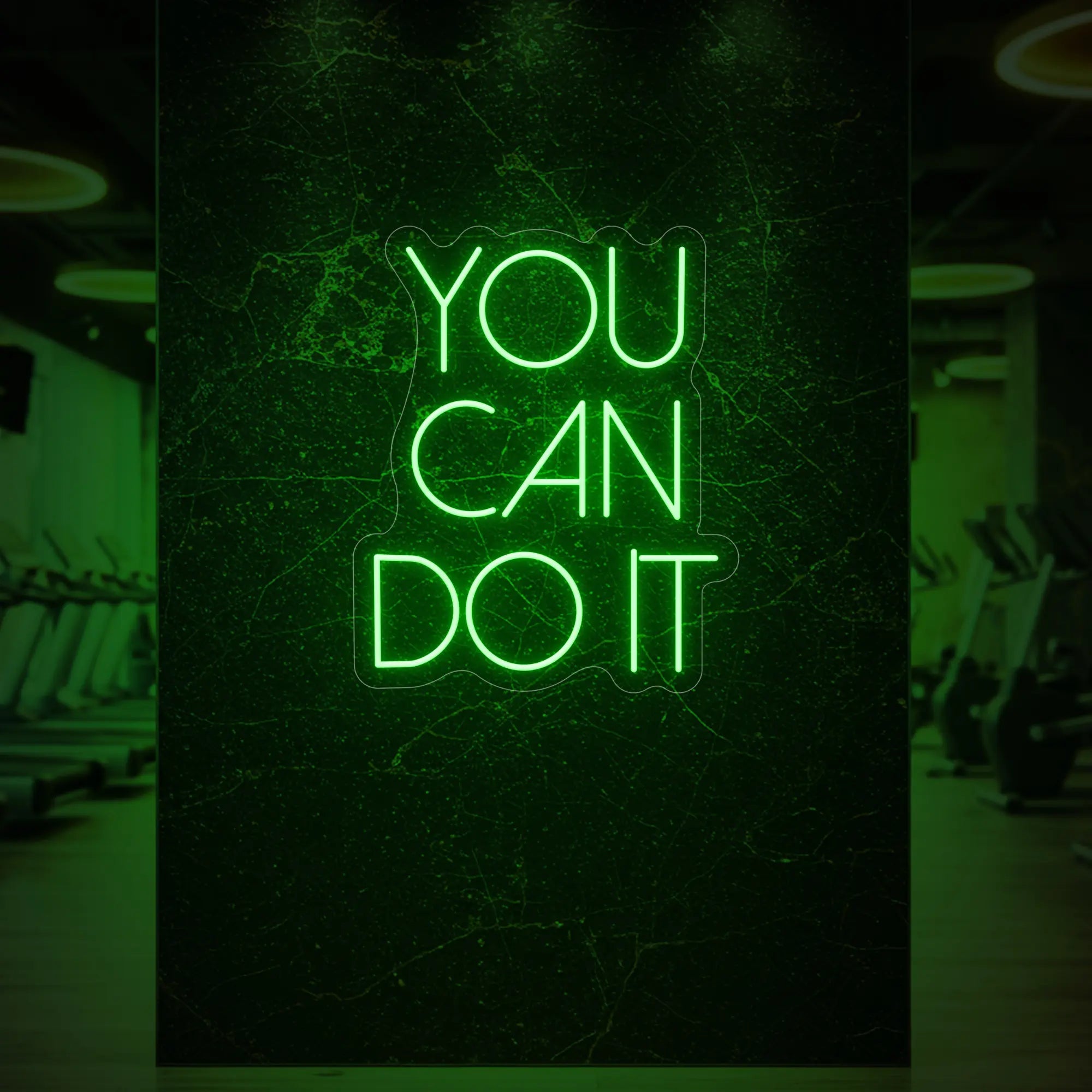 Photo of the 'YOU CAN DO IT' neon sign glowing in green against a styled interior wall.