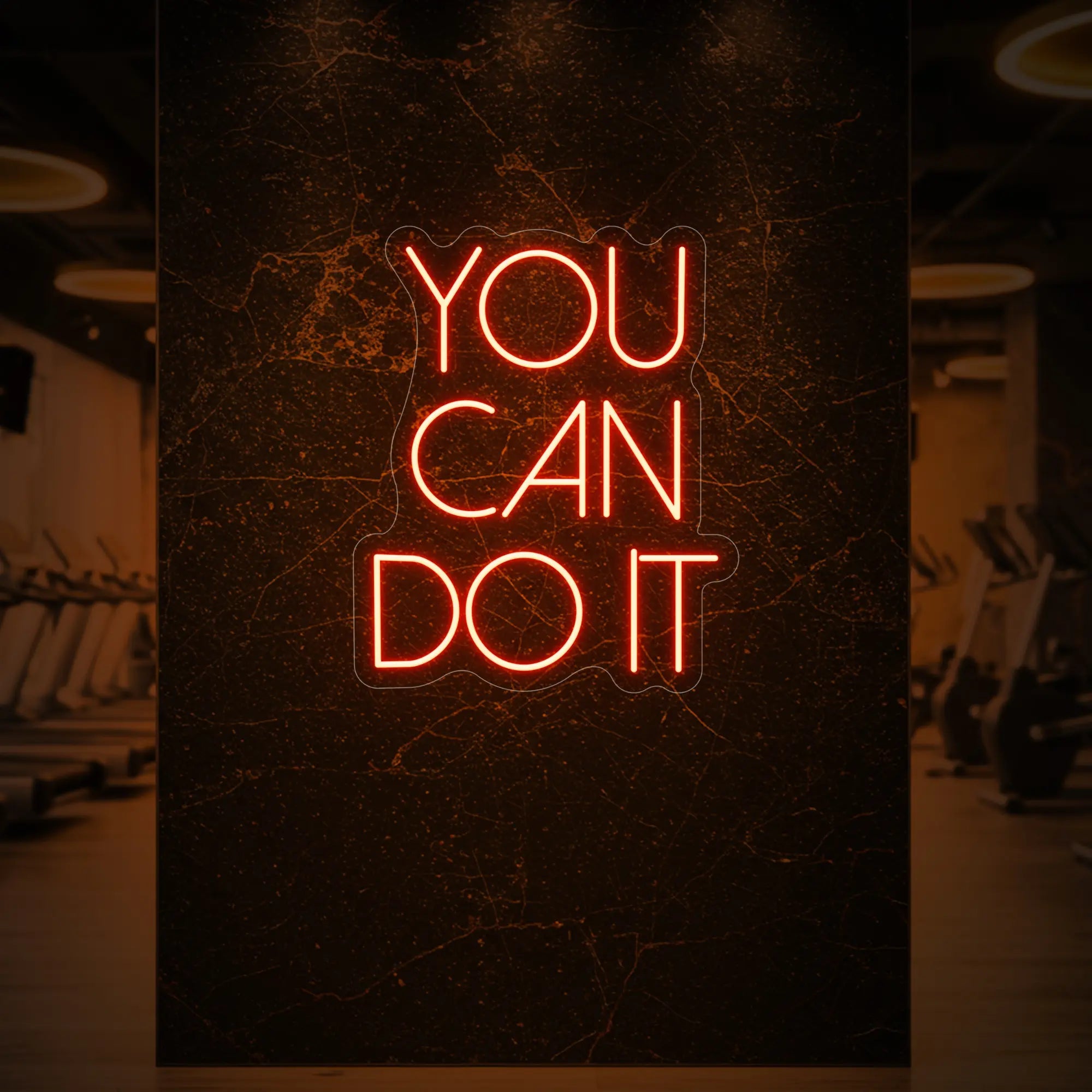 Photo of the 'YOU CAN DO IT' neon sign glowing in golden yellow against a styled interior wall.