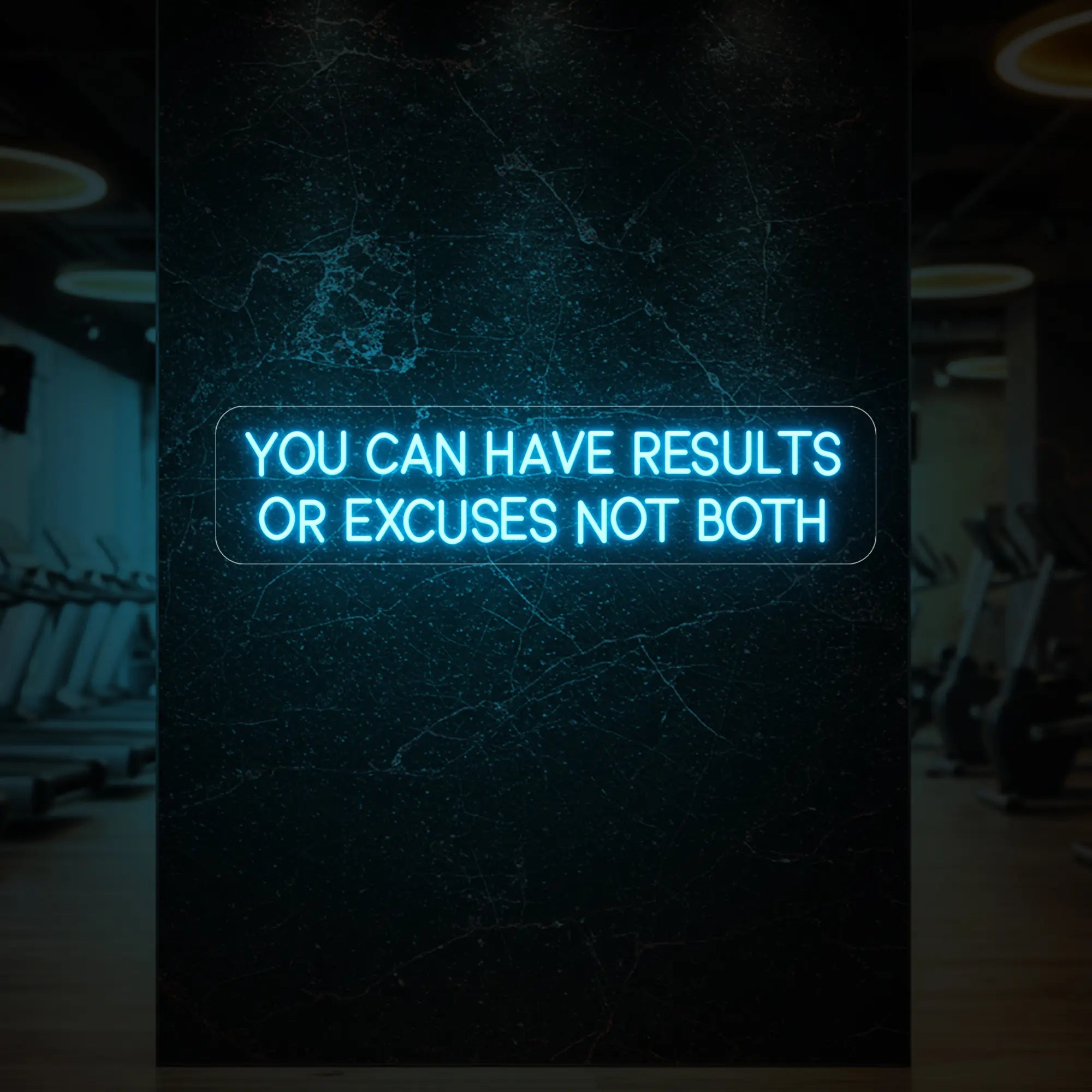 'YOU CAN HAVE RESULTS OR EXCUSES NOT BOTH' neon sign glowing in ice blue against a styled interior wall.