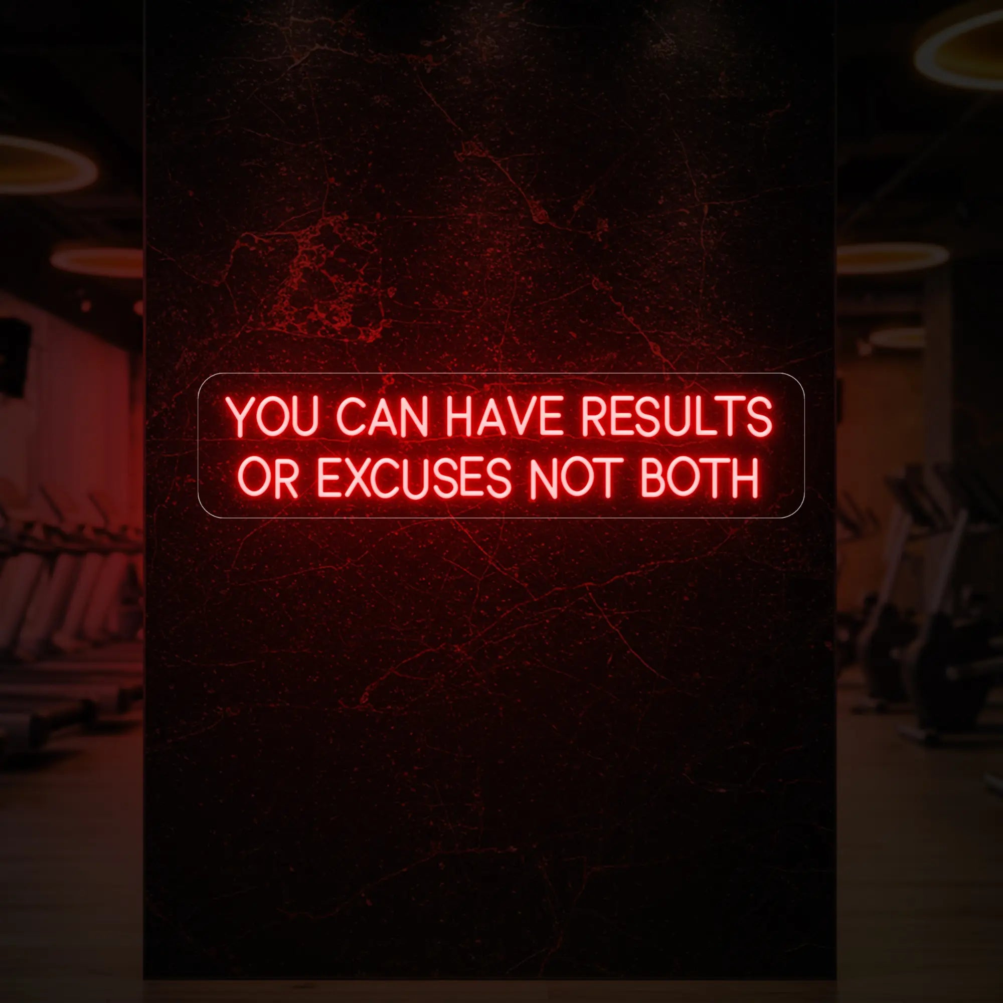 'YOU CAN HAVE RESULTS OR EXCUSES NOT BOTH' neon sign glowing in red against a styled interior wall.
