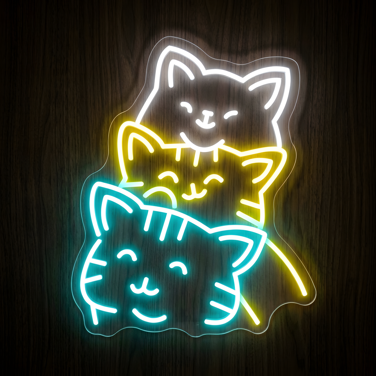 Colorful Kittens LED Neon Sign featuring three cute stacked cat faces illuminated in white, yellow, and turquoise neon on clear acrylic against a dark wood background, ideal for cat lovers, pet stores, cat cafés, veterinary clinics, grooming salons, and playful pet-themed decor.