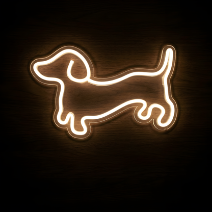 Dachshund Outline LED Neon Sign featuring a minimalist warm white glowing line-art silhouette of a dachshund with its signature long body, floppy ear, short legs, and raised tail on clear acrylic backing against a dark wood wall.