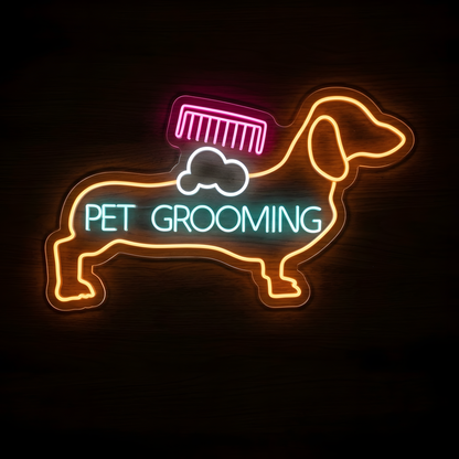 Dachshund Pet Grooming LED Neon Sign featuring an orange dachshund outline with a pink grooming comb, white soap suds, and aqua PET GROOMING lettering on clear acrylic backing against a dark wood wall.