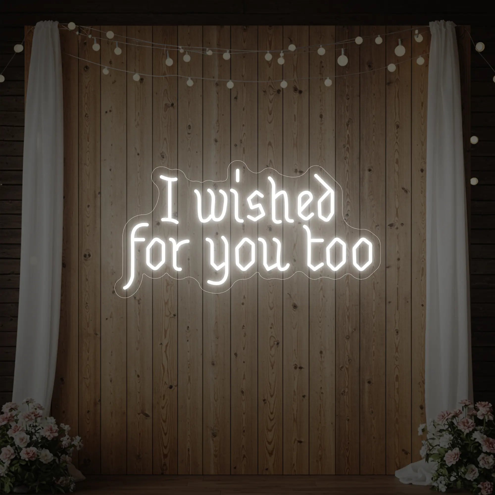 Photo of the 'I Wished For You Too' neon sign glowing in cool white against a styled interior wall.