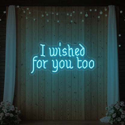 Photo of the 'I Wished For You Too' neon sign glowing in ice blue against a styled interior wall.