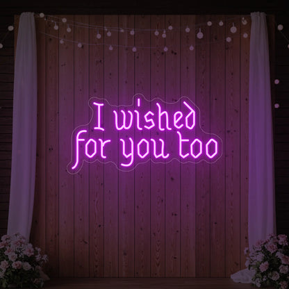 Photo of the 'I Wished For You Too' neon sign glowing in deep pink against a styled interior wall.