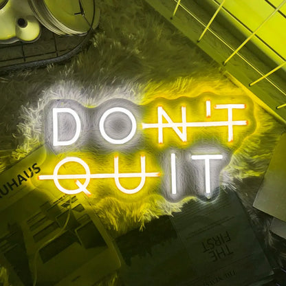 Yellow "DON'T QUIT" neon sign