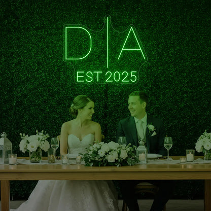 Photo of the 'Wedding Initials Custom Neon Sign V3' neon sign glowing in green against a styled interior wall.