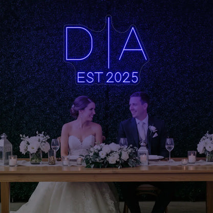 Photo of the 'Wedding Initials Custom Neon Sign V3' neon sign glowing in deep blue against a styled interior wall.