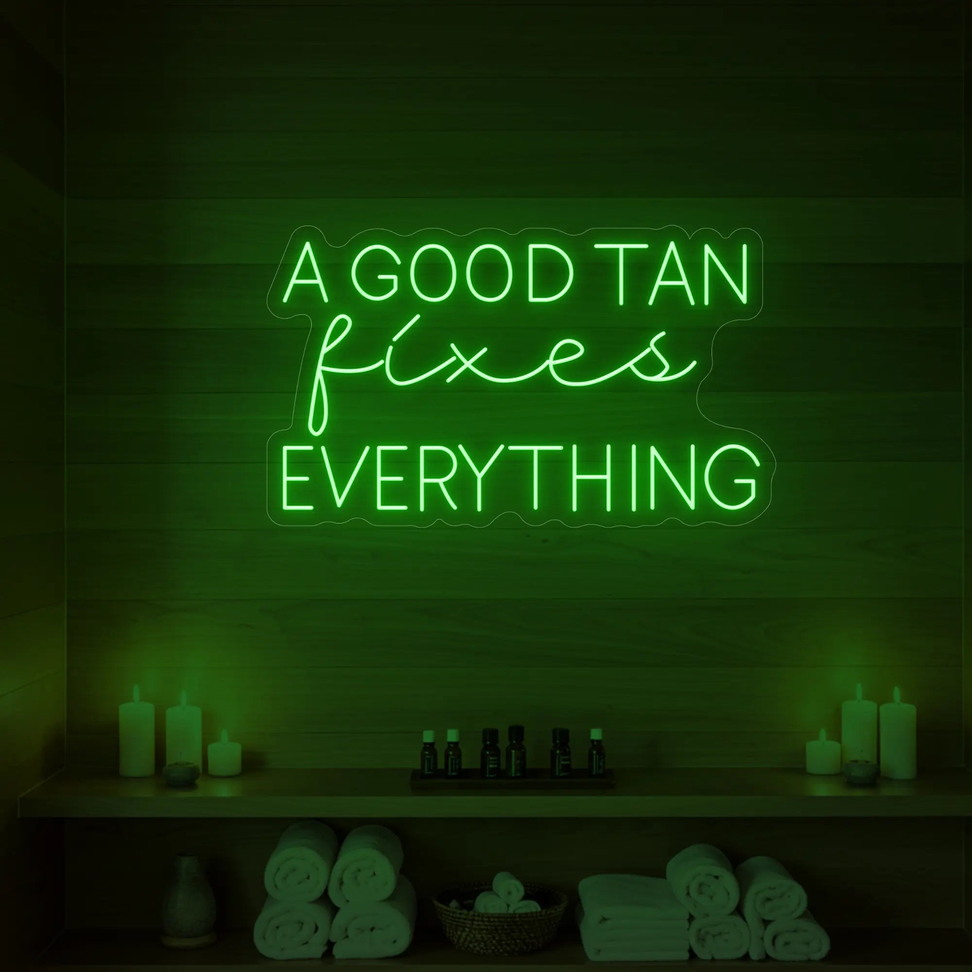Photo of the 'A GOOD TAN fixes EVERYTHING' neon sign glowing in red against a styled interior wall.