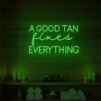Photo of the 'A GOOD TAN fixes EVERYTHING' neon sign glowing in red against a styled interior wall.