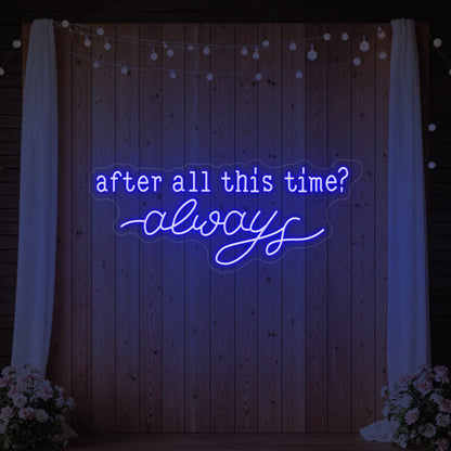 Photo of the 'After All This Time V1' neon sign glowing in deep blue against a styled interior wall.
