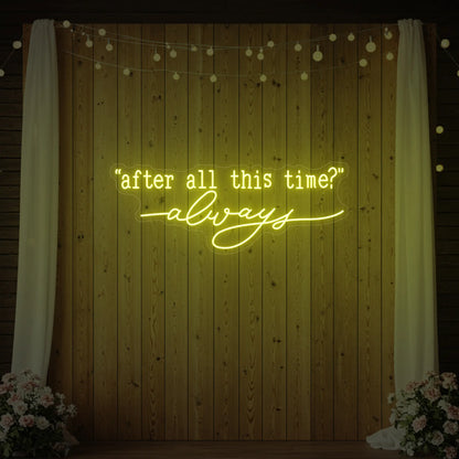 Photo of the 'After All This Time V2' neon sign glowing in lemon yellow against a styled interior wall.