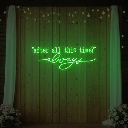 Photo of the 'After All This Time V2' neon sign glowing in green against a styled interior wall.