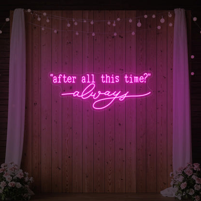 Photo of the 'After All This Time V2' neon sign glowing in light pink against a styled interior wall.