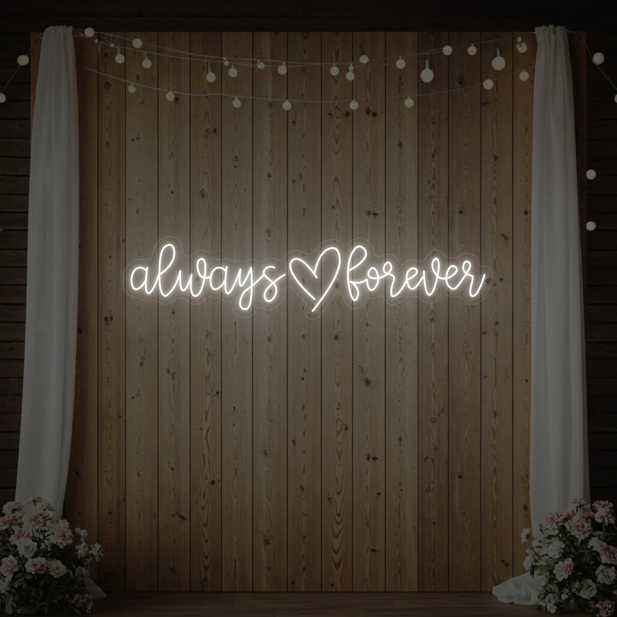 Photo of the 'Always Heart Forever' neon sign glowing in cool white against a styled interior wall.