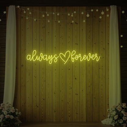 Photo of the 'Always Heart Forever' neon sign glowing in lemon yellow against a styled interior wall.