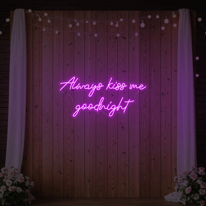Photo of the 'Always Kiss Me Goodnight' neon sign glowing in deep pink against a styled interior wall.