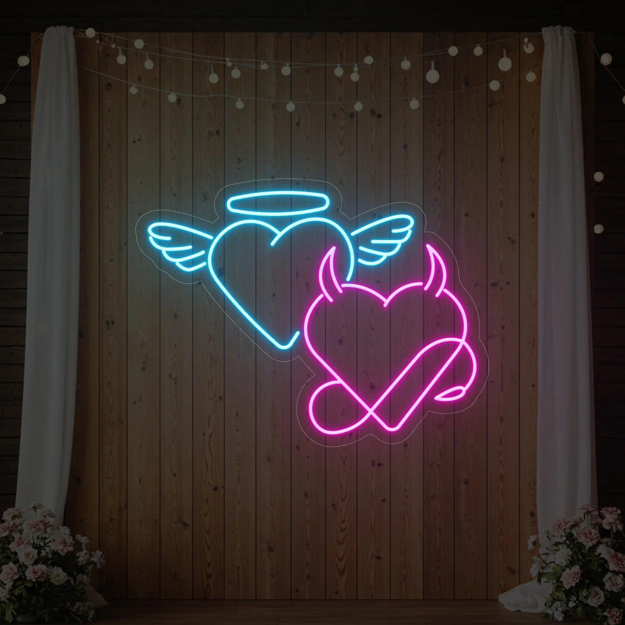 Photo of the 'Angel and Devil Hearts' neon sign glowing in light pink and ice blue against a styled interior wall.