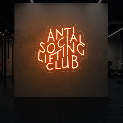  'Anti Social Lifting Club' neon sign glowing in golden yellow against a styled interior wall.