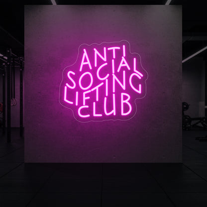  'Anti Social Lifting Club' neon sign glowing in light pink against a styled interior wall.