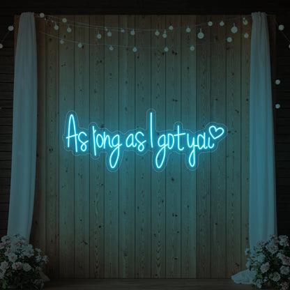 Photo of the 'As Long As I Got You' neon sign glowing in ice blue against a styled interior wall.
