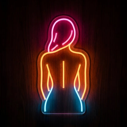 Back and Spine Therapy LED Neon Sign featuring a woman's back silhouette illuminated in pink, orange, and blue neon on clear cut-to-shape acrylic against a dark wooden wall.