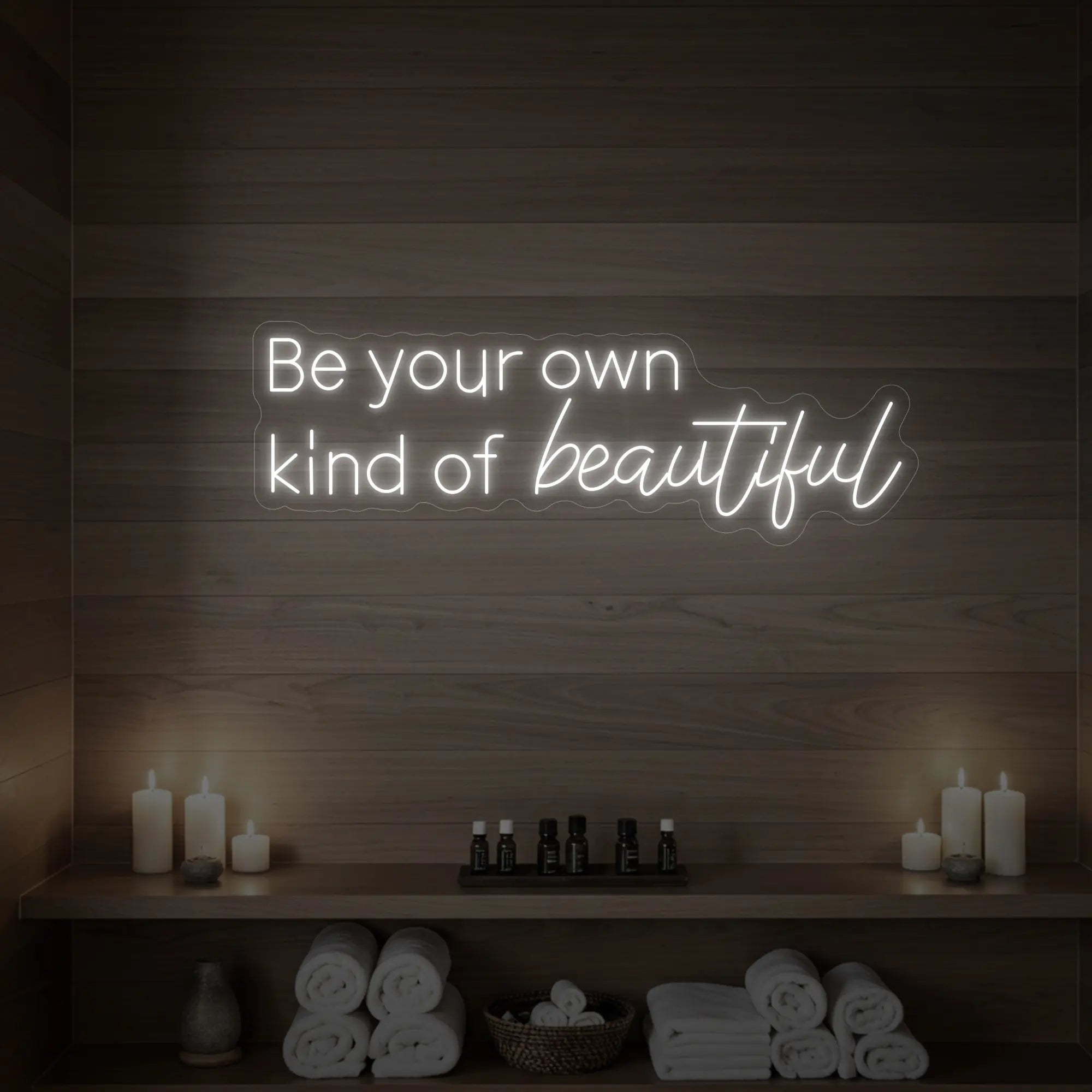 Photo of the 'Be your own kind of beautiful' neon sign glowing in cool white against a styled interior wall.
