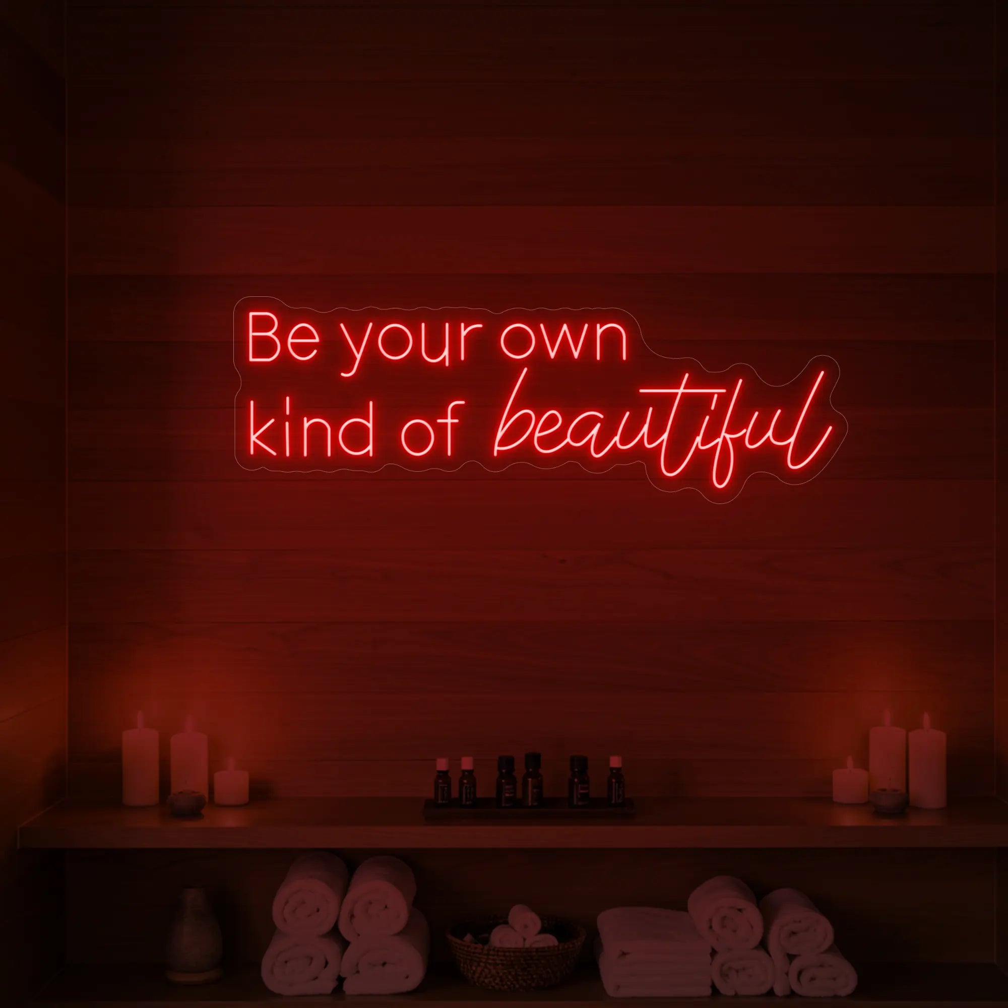 Photo of the 'Be your own kind of beautiful' neon sign glowing in red against a styled interior wall.