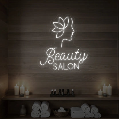 Photo of the 'Beauty Salon' neon sign glowing in cool white against a styled interior wall.