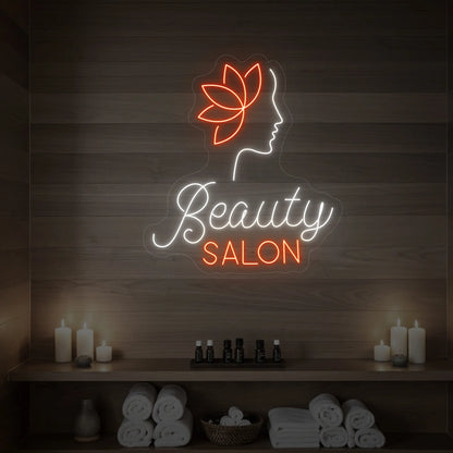 Photo of the 'Beauty Salon' neon sign glowing in cool white and golden yellow against a styled interior wall.