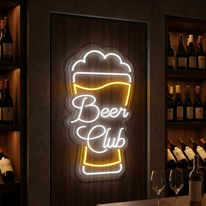 Photo of the 'BEER CLUB' neon sign glowing in cool white and lemon yellow against a styled interior wall.