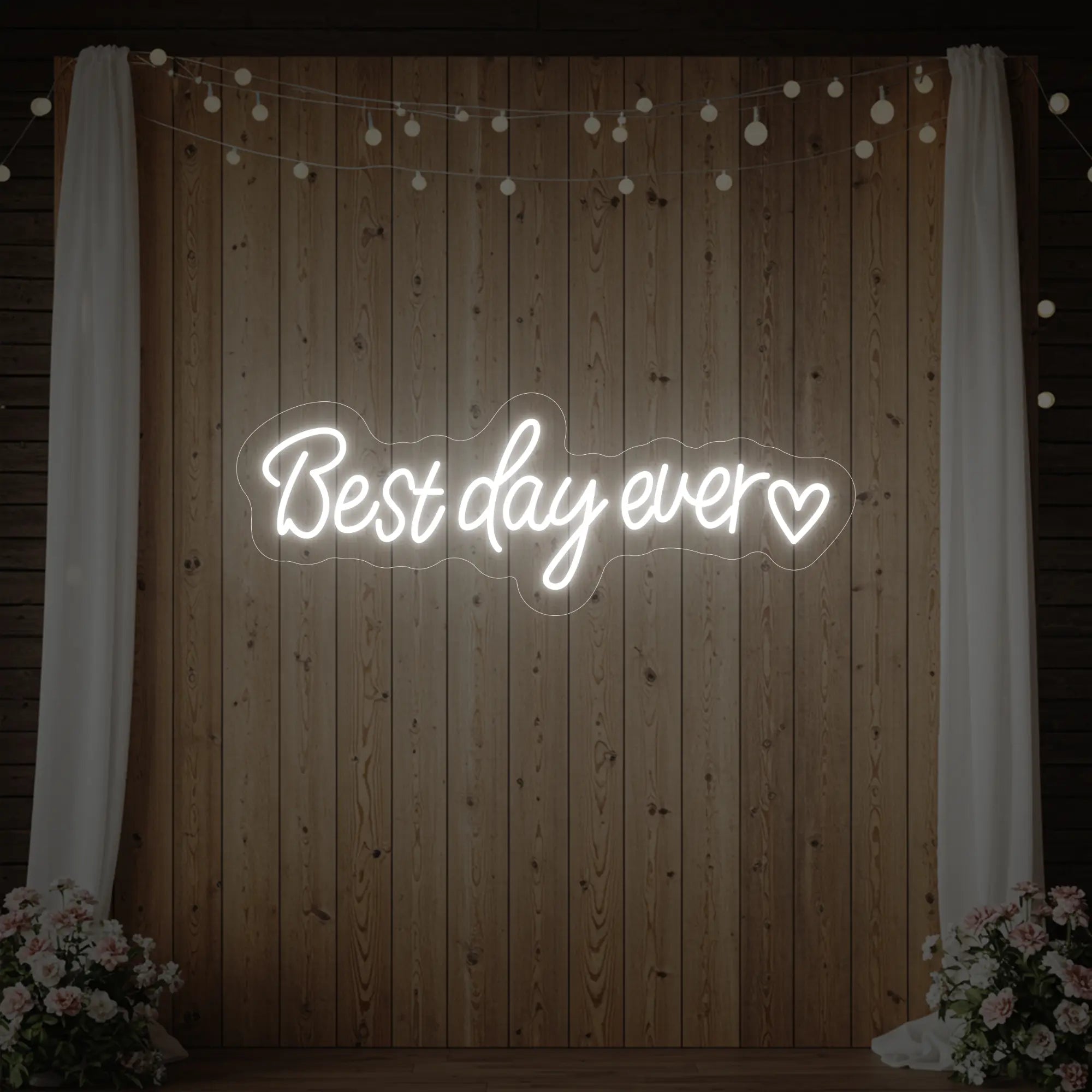 Photo of the 'Best Day Ever Heart' neon sign glowing in cool white against a styled interior wall.