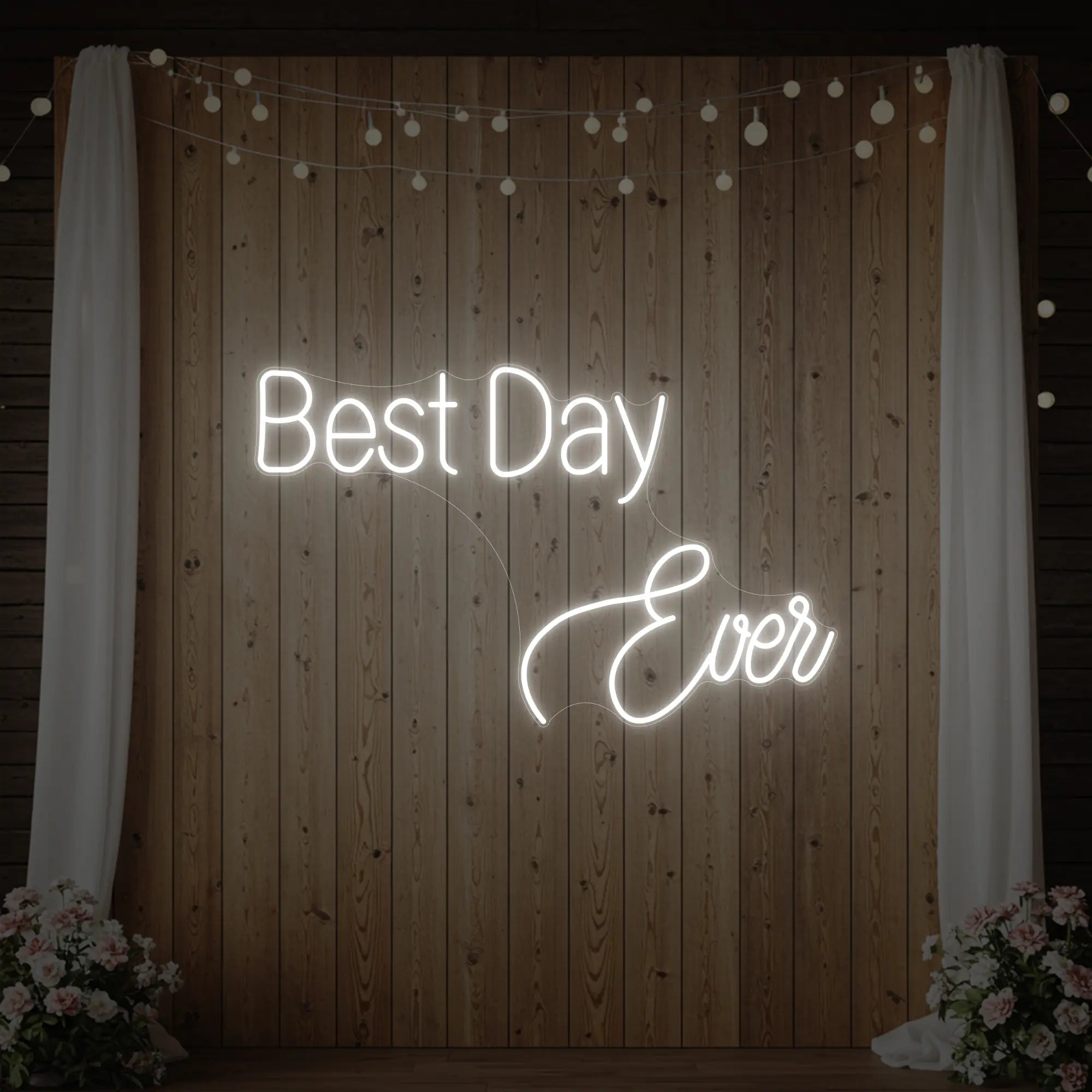 Photo of the 'Best Day Ever' neon sign glowing in cool white against a styled interior wall.