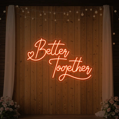 Photo of the 'Better Together' neon sign glowing in golden yellow against a styled interior wall.