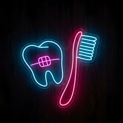 Braces and Toothbrush LED neon sign featuring a blue tooth with pink orthodontic braces beside a pink toothbrush with blue bristles on clear acrylic backing for dental and orthodontic clinic decor.